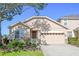 Charming single-Gathering home showcasing a manicured lawn and a two-car garage at 23820 Sardinia Dr, Sorrento, FL 32776