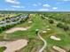 Scenic aerial view of the golf course with sand traps and a well-maintained fairway at 23820 Sardinia Dr, Sorrento, FL 32776