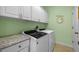 Laundry room with modern washer and dryer, granite countertop, and upper cabinets at 23820 Sardinia Dr, Sorrento, FL 32776