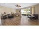 Bright and spacious living room with wood floors and sliding glass doors to the outdoors at 23820 Sardinia Dr, Sorrento, FL 32776