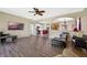 Open living area with wood flooring, kitchen access, and a large television at 23820 Sardinia Dr, Sorrento, FL 32776