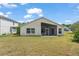 Back of home with a screened-in lanai and lush green lawn at 2511 Brookstone Dr, Kissimmee, FL 34744