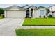 Charming one-story home featuring an attached two-car garage and well-manicured lawn at 2511 Brookstone Dr, Kissimmee, FL 34744