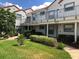 Attractive two-story condo building with well-manicured lawn, mature landscaping, and covered parking at 2524 Woodgate Blvd # 201, Orlando, FL 32822