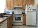 Kitchen features an oven, microwave, refrigerator, wood cabinets, and tile countertops at 2524 Woodgate Blvd # 201, Orlando, FL 32822
