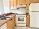 Efficient kitchen with wooden cabinets, white appliances, and tiled countertops, ready for cooking at 2524 Woodgate Blvd # 201, Orlando, FL 32822
