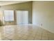 Spacious living room with tile floors, natural light from sliding glass door and a window at 2524 Woodgate Blvd # 201, Orlando, FL 32822