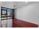 Well-lit bedroom with hardwood floors, large window overlooking the city, and modern window treatments at 260 S Osceola Ave # 1207, Orlando, FL 32801