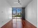 Bedroom with hardwood floors, city views through a large window, and contemporary ceiling fan at 260 S Osceola Ave # 1207, Orlando, FL 32801