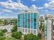 Modern condo building featuring a sleek design with expansive windows and a rooftop terrace, set against a vibrant cityscape at 260 S Osceola Ave # 1207, Orlando, FL 32801