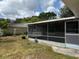 This backyard includes a screened porch with a green lawn at 2747 Rose Moss Ln, Orlando, FL 32807