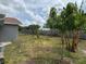 The backyard features grass with trees and shrubs, along with a wooden fence at 2747 Rose Moss Ln, Orlando, FL 32807
