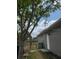 The backyard features a grey house with a mango tree in the foreground at 2747 Rose Moss Ln, Orlando, FL 32807