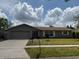 Charming single-story home featuring a well-maintained lawn and an attached two-car garage at 2747 Rose Moss Ln, Orlando, FL 32807