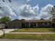 Charming single-story home featuring a well-maintained lawn and an attached two-car garage at 2747 Rose Moss Ln, Orlando, FL 32807
