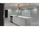 Modern kitchen with stainless steel appliances, white cabinets, a center island, and stylish light fixtures at 2747 Rose Moss Ln, Orlando, FL 32807