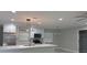 Modern kitchen with stainless steel appliances, white cabinets, a center island, and stylish light fixtures at 2747 Rose Moss Ln, Orlando, FL 32807