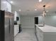 Modern kitchen with stainless steel appliances, white cabinets, and a center island with quartz countertops at 2747 Rose Moss Ln, Orlando, FL 32807