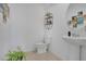 A modern bathroom with a pedestal sink, round mirror, and black shelving at 2834 Common Crane Ct, St Cloud, FL 34773