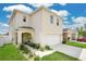 Two-story home with neutral siding, an attached garage and a covered porch with seating at 2834 Common Crane Ct, St Cloud, FL 34773