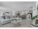 Open concept living room with views into the kitchen and dining area, and a large sectional sofa at 2834 Common Crane Ct, St Cloud, FL 34773