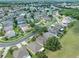 An aerial view of a residential neighborhood with green spaces, sidewalks, and tree-lined streets at 2956 White Cedar Cir, Kissimmee, FL 34741