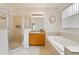 Bright bathroom with a separate shower and soaking tub, complemented by wood cabinets at 2956 White Cedar Cir, Kissimmee, FL 34741