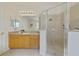 Well-lit bathroom showcasing a glass-enclosed shower and a vanity with cabinet storage at 2956 White Cedar Cir, Kissimmee, FL 34741