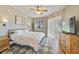 Bright bedroom featuring a ceiling fan, TV, and a cozy rug on the wooden floors at 2956 White Cedar Cir, Kissimmee, FL 34741