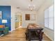 A dining room with modern chandelier, and farmhouse style dining table, and an open view to the kitchen at 2956 White Cedar Cir, Kissimmee, FL 34741
