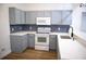 Updated kitchen features modern appliances, gray cabinets, white countertops and stylish backsplash at 30101 Pga Dr, Sorrento, FL 32776