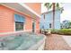 Paver patio with hot tub, outdoor dining set, and colorful exterior at 3062 Pirate Way, Kissimmee, FL 34747