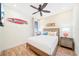A cozy bedroom with a ceiling fan, beachy decor, a wood-framed bed, and decorative pillows at 3062 Pirate Way, Kissimmee, FL 34747