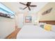 Relaxing bedroom featuring beach-themed art, wood-look tile flooring, and a comfortable bed, with a TV and lots of light at 3062 Pirate Way, Kissimmee, FL 34747