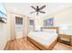 This bedroom has a wood-look floor, ceiling fan, beach artwork, and a bed with bedside tables and lamps at 3062 Pirate Way, Kissimmee, FL 34747