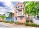 Quaint peach-colored two-story home featuring blue shutters and a small balcony, nestled among lush greenery at 3062 Pirate Way, Kissimmee, FL 34747