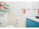 A charming half bathroom features a blue vanity, beach-themed decor, and a convenient towel rack, with a toilet and mirror at 3062 Pirate Way, Kissimmee, FL 34747