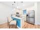 Bright kitchen featuring white cabinets, stainless steel appliances, a breakfast bar, and a modern aesthetic at 3062 Pirate Way, Kissimmee, FL 34747