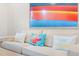 Comfortable living room featuring a neutral sofa with decorative pillows and modern artwork at 3062 Pirate Way, Kissimmee, FL 34747