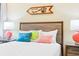 A bright main bedroom with a decorative headboard, two side tables, and coastal-themed wall art at 3062 Pirate Way, Kissimmee, FL 34747