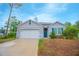 Charming single-story home with a two-car garage, landscaped yard, and welcoming entrance at 3479 Courtland Blvd, Deltona, FL 32738