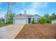 Well-maintained single-Gathering home featuring a two-car garage, pleasant landscaping, and a blue front door at 3479 Courtland Blvd, Deltona, FL 32738