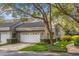 Charming townhome featuring a gray exterior, tile roof, and a two-car garage, complemented by lush landscaping and a tree canopy at 3987 Lancashire Ln # 3987, Longwood, FL 32779