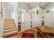 Bright foyer featuring a staircase, hardwood floors, mirrored walls, and a decorative rug, offering a grand entrance at 3987 Lancashire Ln # 3987, Longwood, FL 32779
