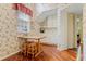 Bright eat-in kitchen featuring cozy breakfast table, floral wallpaper, and hardwood floors at 3987 Lancashire Ln # 3987, Longwood, FL 32779