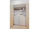 Bright laundry room featuring a stacked washer and dryer, shelving, and lots of room for storage at 3987 Lancashire Ln # 3987, Longwood, FL 32779