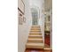 A brightly lit stairway leading to an upper level, complete with art and decorative mirror at 3987 Lancashire Ln # 3987, Longwood, FL 32779
