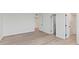 Open bedroom showing light wood floors, white walls and baseboards, and recessed ceiling lights at 400 E Colonial Dr # 402, Orlando, FL 32803