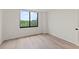 Bright bedroom featuring wood-look flooring and a large window with a scenic view at 400 E Colonial Dr # 402, Orlando, FL 32803
