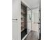 Modern closet features dark tile flooring, shelves, and mirrored doors to a bedroom with hardwood floors at 400 E Colonial Dr # 402, Orlando, FL 32803